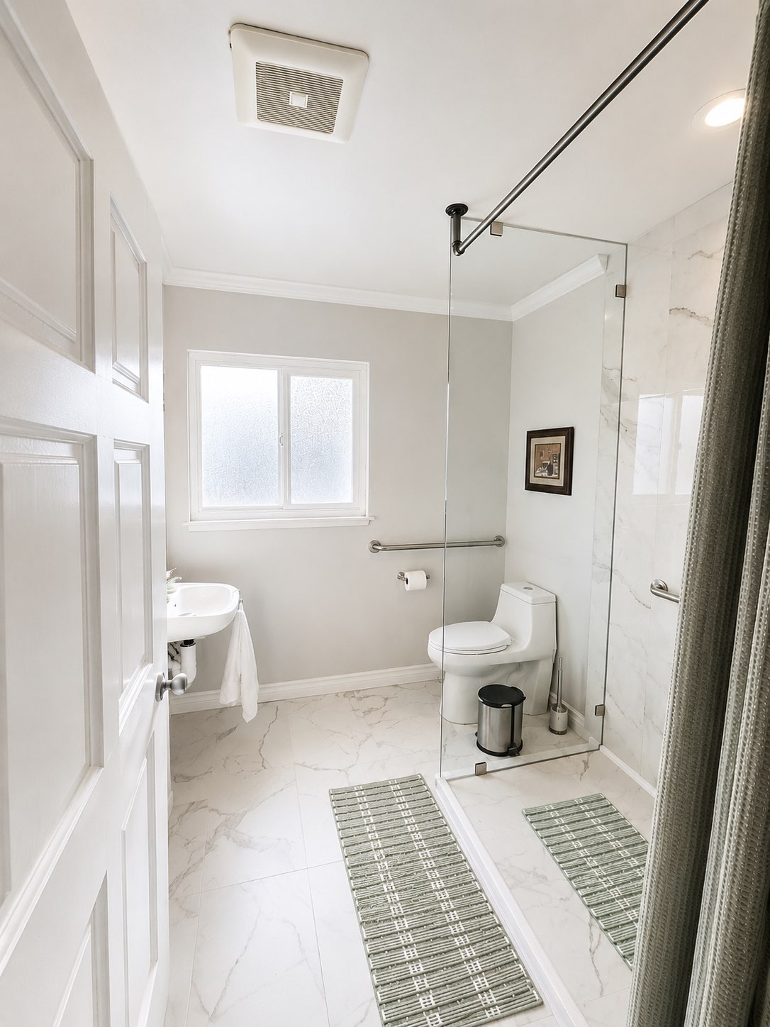 Accessible bathroom with a walk-in glass shower, grab bar, and marble tile